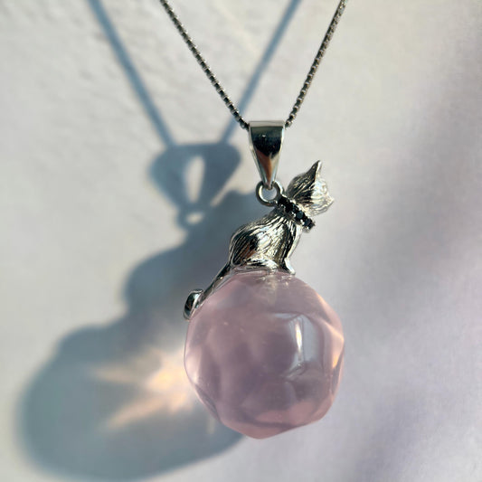 Pink pendant necklace with silver chain on a light background