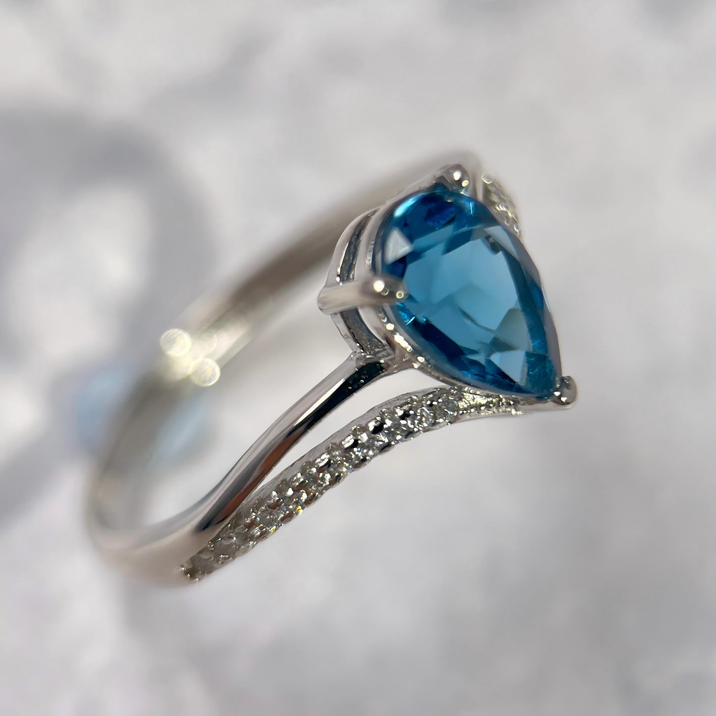Silver ring with a blue gemstone on a white background