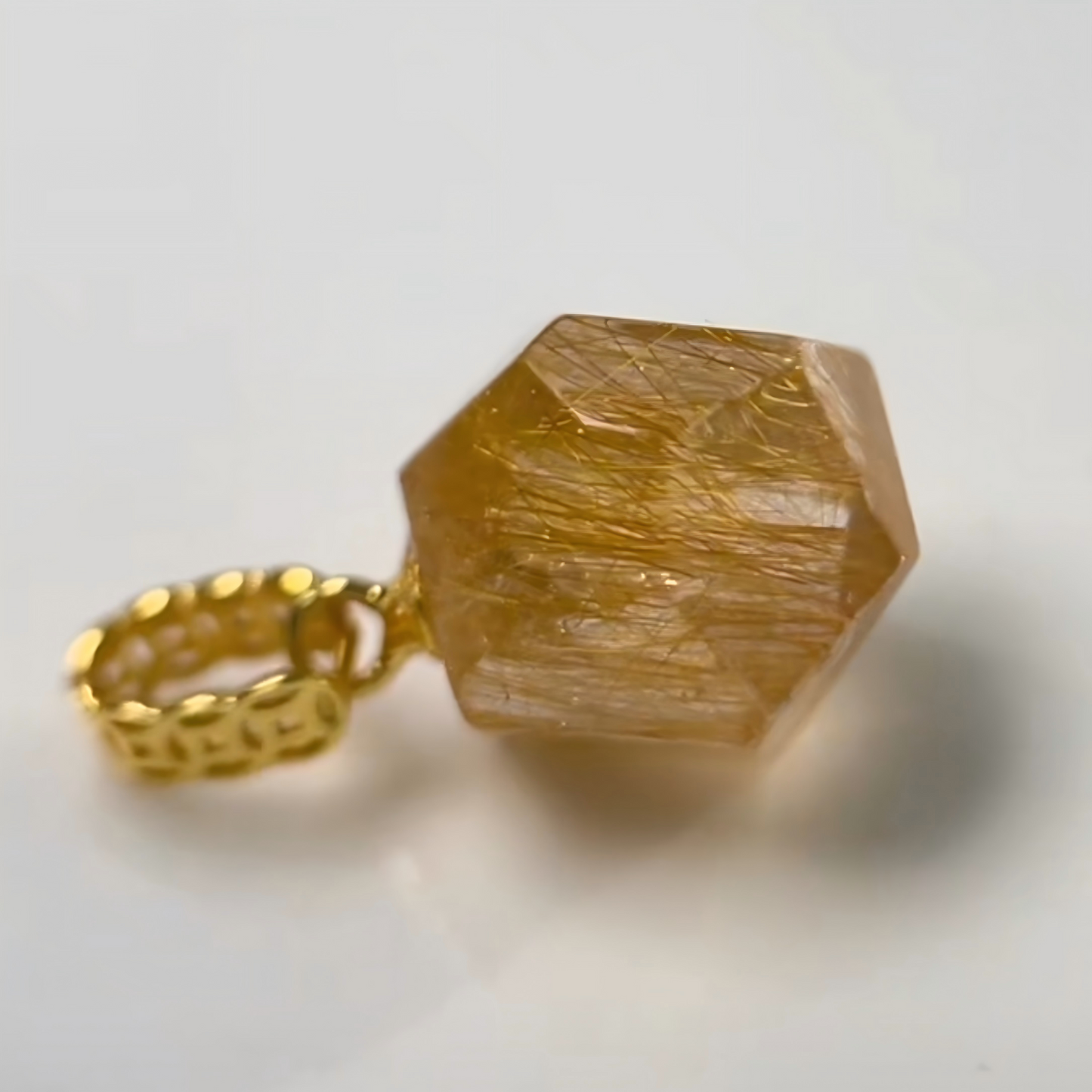 Gold Rutilated Quartz Pendant with a large, faceted yellow stone on a white background