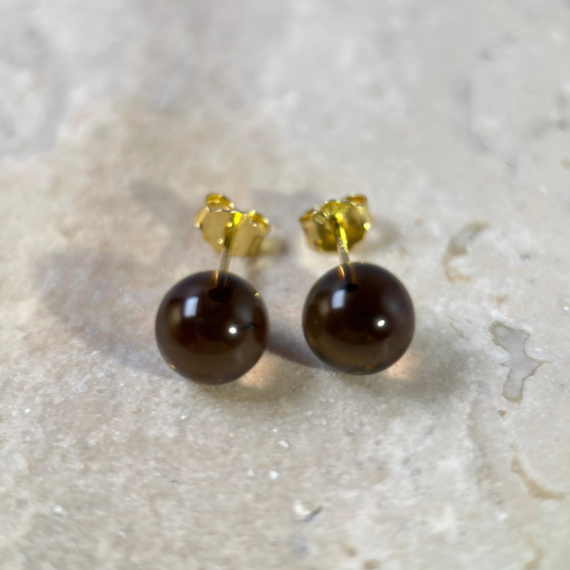 Warm Shade smoky quartz stud earrings with detachable chain drops shown on a marble surface