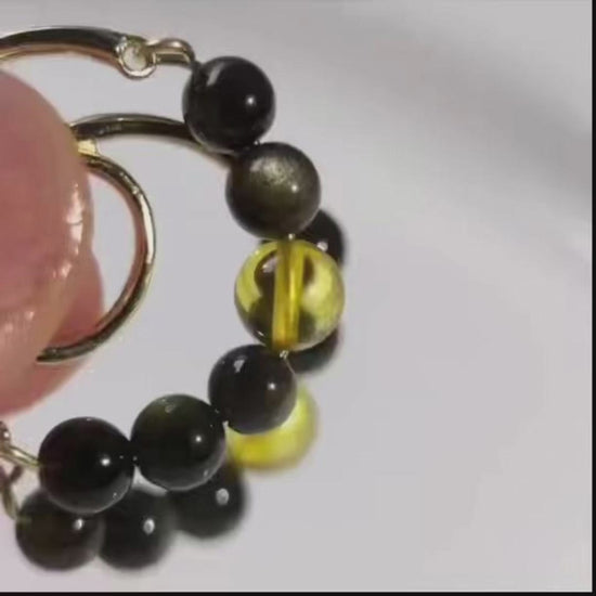 Close-up video of Night Light golden sheen obsidian and amber beaded hoop earrings, showing the stones and gold-plated hoop details.