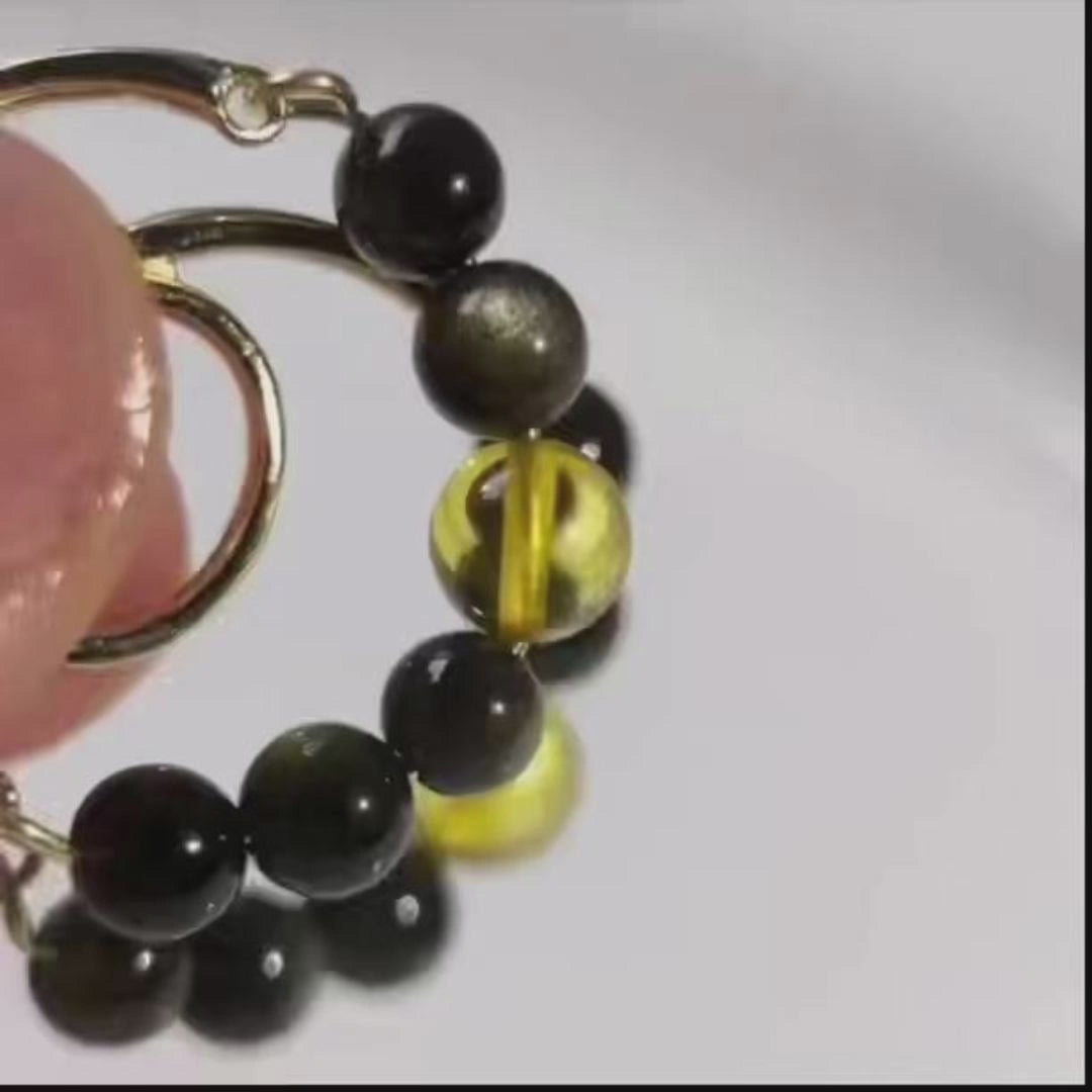 Close-up video of Night Light golden sheen obsidian and amber beaded hoop earrings, showing the stones and gold-plated hoop details.