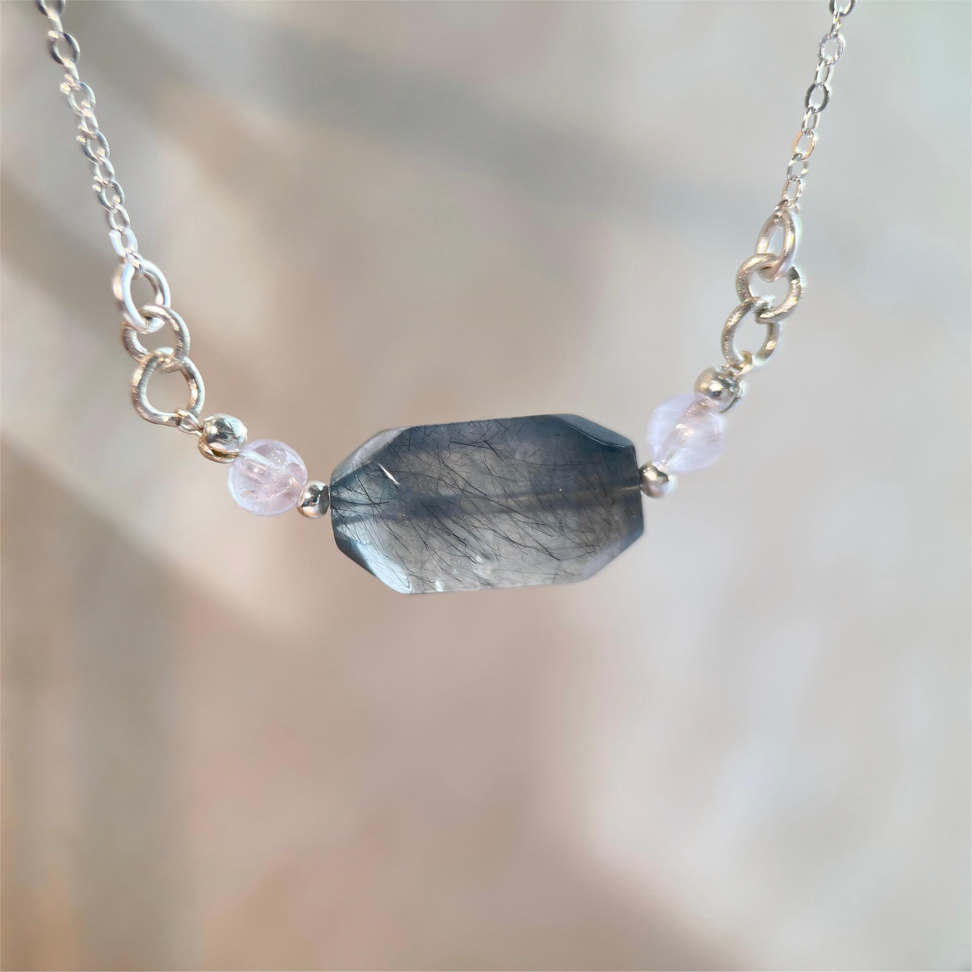 Necklace with a faceted gemstone pendant on a blurred background