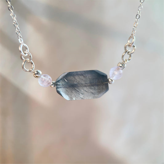 Necklace with a faceted gemstone pendant on a blurred background