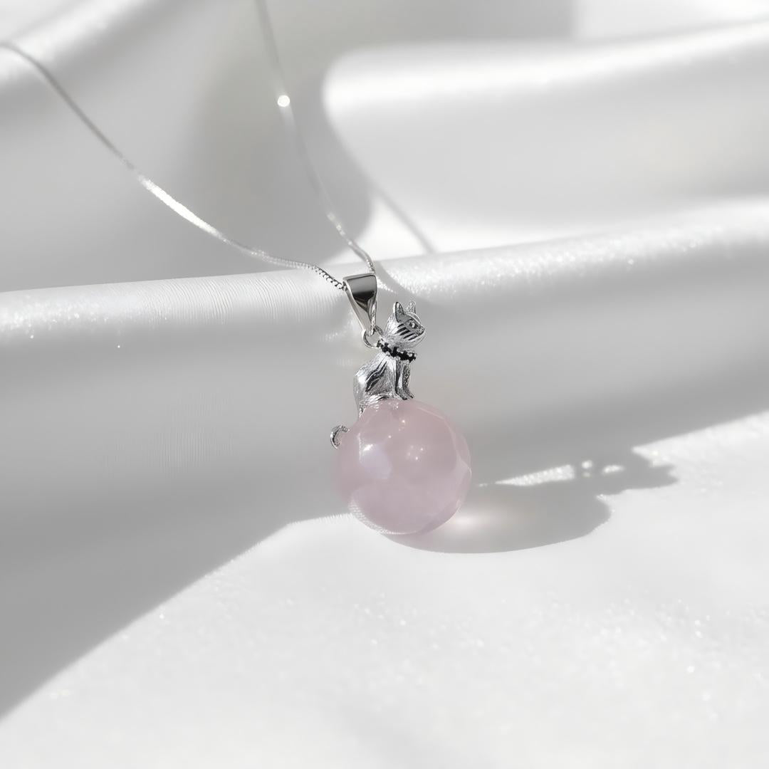 Pink gemstone pendant on a silver chain against a white background